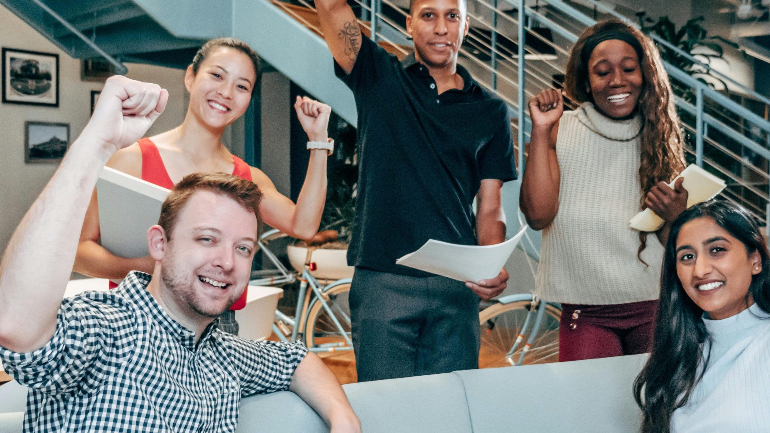 pexels-photo-7688161-7688161 A diverse group of coworkers celebrating success in a modern office setting, showcasing teamwork and collaboration.